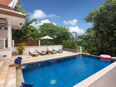 a swimming pool with chairs and an umbrella next to a house at Katamanda 3 Bed Tropical Villa B3 Near Kata Beach in Kata Beach
