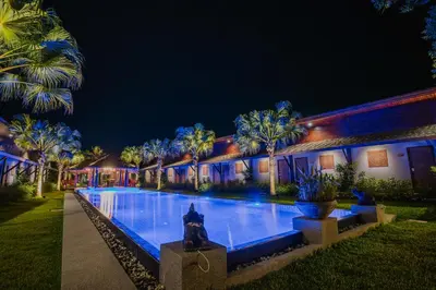 a house with a swimming pool at night at Malabar Pool Villa Phuket in Phuket Town