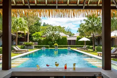 a view of a swimming pool with drinks on a table at Malabar Pool Villa Phuket in Phuket Town