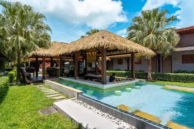 a villa with a swimming pool and a straw hut at Malabar Pool Villa Phuket in Phuket Town