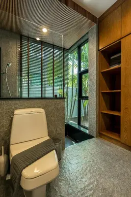 a bathroom with a toilet in a room with windows at Baan Bua BT17 by Villacarte in Nai Harn Beach