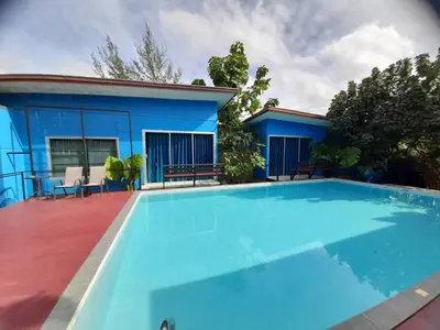 a large blue swimming pool in front of a house at RadHut in Chalong