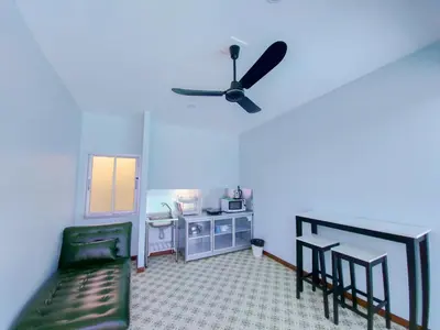 a living room with a ceiling fan and a couch at RadHut in Chalong