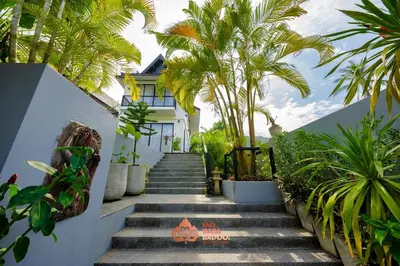 a stairway leading up to a white house with palm trees at Yao Bada Badoo Boutique Resort in Ko Yao Yai