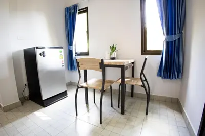 a small table and chairs in a room with a refrigerator at Grand View Premium in Patong Beach
