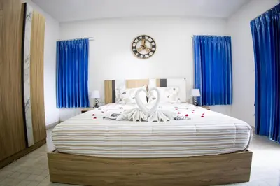 a bedroom with a large bed with blue curtains at Grand View Premium in Patong Beach