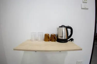 a coffee pot on a wooden shelf on a wall at Grand View Premium in Patong Beach