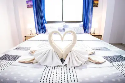 a bed with two swans made to look like hearts at Grand View Premium in Patong Beach