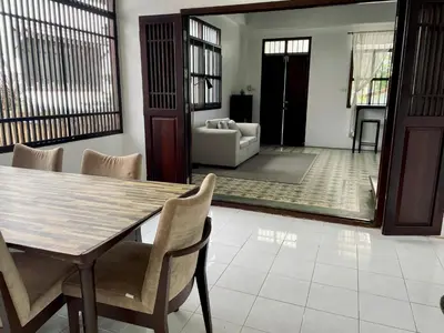a dining room with a table and chairs and a living room at 103/24 Kathu Waterfall in Phuket Town