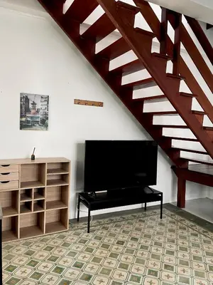 a living room with a flat screen tv and a staircase at 103/24 Kathu Waterfall in Phuket Town