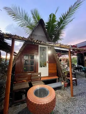 a small house with a large tire in front of it at PhuketAirportCamping in Mai Khao Beach