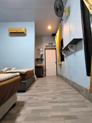a hallway with beds and a door in a room at PhuketAirportCamping in Mai Khao Beach