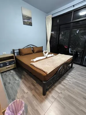 a large bed in a room with a window at PhuketAirportCamping in Mai Khao Beach