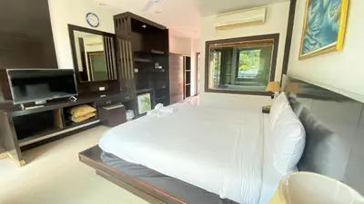 a bedroom with a bed and a flat screen tv at SM Patong Resort in Patong Beach