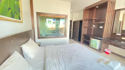 a bedroom with a white bed and a window at SM Patong Resort in Patong Beach