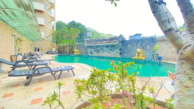 a swimming pool with benches in a building at SM Patong Resort in Patong Beach