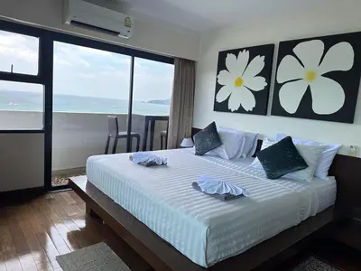 a bedroom with a large bed with a view of the ocean at Patong Tower Ocean View Apartment in Patong Beach