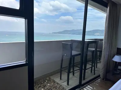 a balcony with chairs and a view of the ocean at Patong Tower Ocean View Apartment in Patong Beach