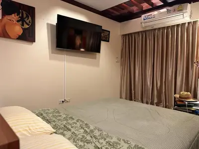 a bedroom with a bed and a flat screen tv on the wall at Patong Tower Ocean View Apartment in Patong Beach