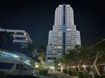 a tall white building at night in a city at Patong Tower Ocean View Apartment in Patong Beach