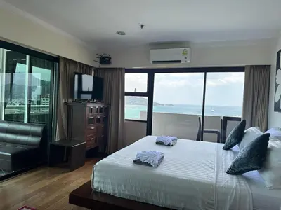 a bedroom with a bed with a view of the ocean at Patong Tower Ocean View Apartment in Patong Beach