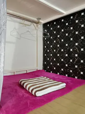a room with a towel on a purple rug at STPhostel in Patong Beach