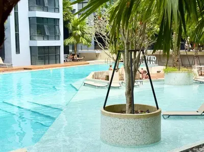 a palm tree sitting next to a swimming pool at Kamala Beach P79 Exclusive Junior Suite in Kamala Beach