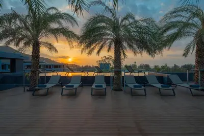 a group of chairs sitting on a patio with palm trees at Kamala Beach P79 Exclusive Junior Suite in Kamala Beach
