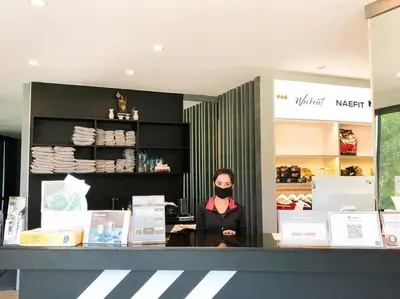 a woman wearing a face mask standing behind a counter at Kamala Beach P79 Exclusive Junior Suite in Kamala Beach