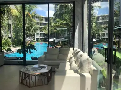 a living room with a white couch and a pool at Daimond Exclusive Junior Suite Bangtau Beach in Bang Tao Beach
