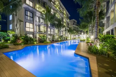 a large blue swimming pool in front of a building at Daimond Exclusive Junior Suite Bangtau Beach in Bang Tao Beach