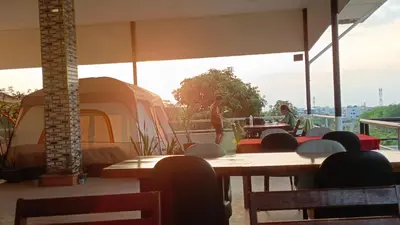 a room with tables and chairs and a tent at Batikseafood Airport & Room in Nai Yang Beach