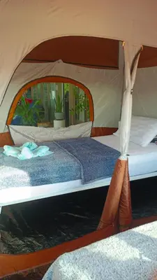 a bedroom with two beds in a tent at Batikseafood Airport & Room in Nai Yang Beach
