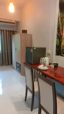 a kitchen with a table with two chairs and a refrigerator at Batikseafood Airport & Room in Nai Yang Beach