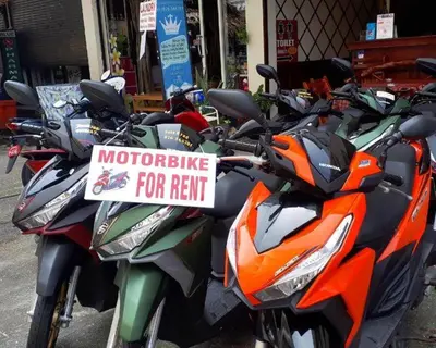 a row of motorcycles parked on a street with a sign at Centre Point Patong in Patong Beach