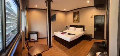 a hotel room with a bed and a window at Centre Point Patong in Patong Beach