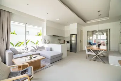 a living room with a couch and a table at Deluxe pool villa at Kamala Garden View in Kamala Beach