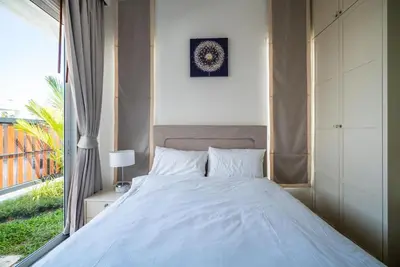 a bedroom with a large bed with a window at Deluxe pool villa at Kamala Garden View in Kamala Beach
