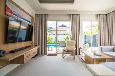 a living room with a large television and a couch at Deluxe pool villa at Kamala Garden View in Kamala Beach