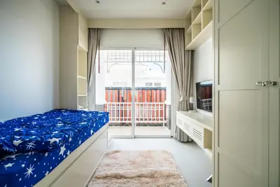 a bedroom with a bed with blue sheets and a television at Deluxe pool villa at Kamala Garden View in Kamala Beach