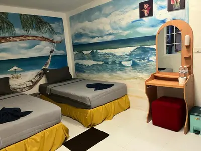 a room with two beds and a painting on the wall at Reggaeinn in Phi Phi Don