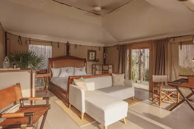 a bedroom with a bed and a couch and a table at Aladdin Luxury Camp Phuket in Phuket Town