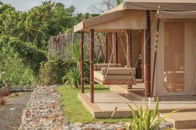 a porch swing with a couch in a garden at Aladdin Luxury Camp Phuket in Phuket Town