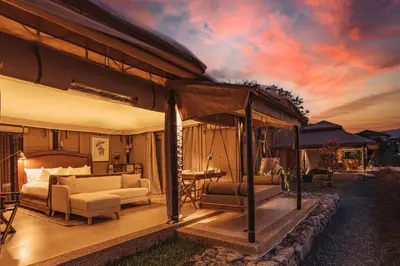 a bedroom with a bed and a couch and a table at Aladdin Luxury Camp Phuket in Phuket Town