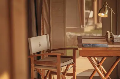 a wooden chair sitting next to a desk with a laptop at Aladdin Luxury Camp Phuket in Phuket Town