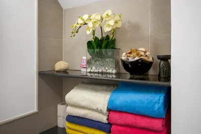 a shelf with towels and a vase with flowers at Laguna Luxury 2-Bed Pool Villa - Near Layan Beach in Layan Beach