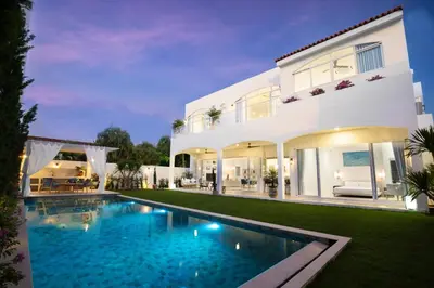a large white house with a swimming pool in front of it at Nai Harn Beach 4 bedroom Pool Villa, Rawai, Phuket in Phuket Town