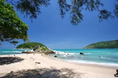 a beach with people swimming in the ocean at Nai Harn Beach 4 bedroom Pool Villa, Rawai, Phuket in Phuket Town