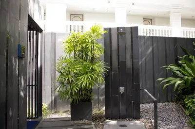 a black fence with two plants in a courtyard at The Deck Condo Studios Patong w/ pool fitness in Patong Beach