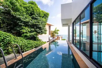 an infinity pool in a house with a view of the ocean at mona seaview pool villa beach front AoYon Beach in Panwa Beach